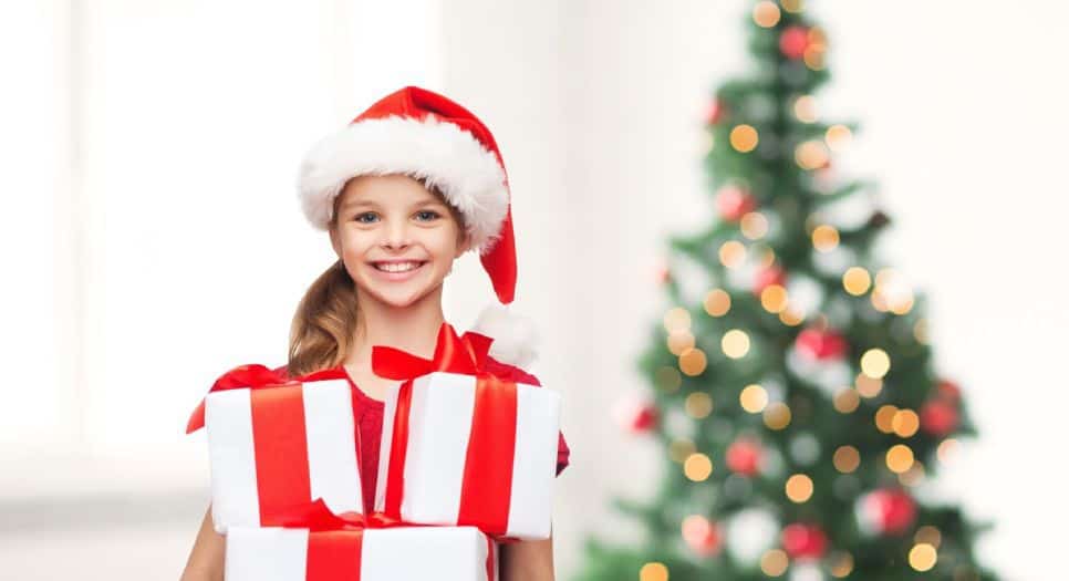 Foto di una bambina felice con regali di Natale