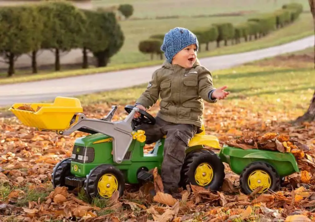 bambino gioca su un trattore in giardino
